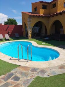 a swimming pool in front of a house at Casa Rural Lares in Casas de Don Pedro