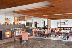 a restaurant with tables and chairs and a bar at Four Points by Sheraton Jaipur, City Square in Jaipur