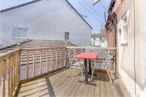 a small balcony with a red table and chairs on it at 2Bedrooms, 4beds cosy family home, Free WiFi, Stay UK Homes in Birmingham