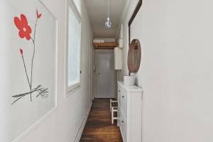 a hallway with white walls and wood floors and a mirror at Unit 016 Marais Turenne in Paris