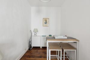 a kitchen with white walls and a table with stools at Unit 016 Marais Turenne in Paris