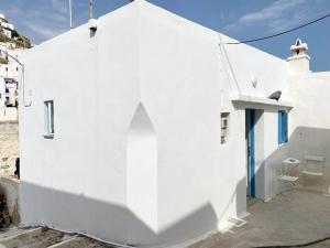 a white building with a shadow on the side of it at Cyclops House in Serifos Chora