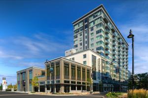 un grande edificio su una strada cittadina con un lampione di The Row Hotel at Assembly Row, Autograph Collection a Somerville