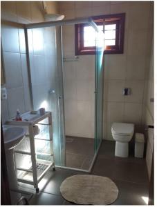 a bathroom with a shower and a toilet and a sink at Suíte em casa de campo in Carlos Barbosa