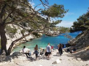 a group of people walking on a beach near a body of water at appartement terrasse pkg au pied plages du prado in Marseille