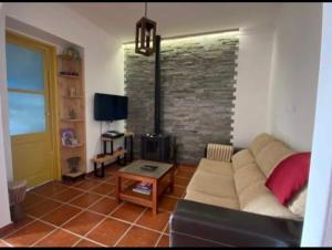 sala de estar con sofá y pared de ladrillo en Buganvilla Alentejo, en São Francisco da Serra