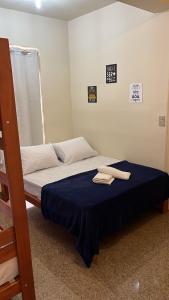 a bed with two towels on it in a room at Nuh Hostel - Lourdes in Belo Horizonte