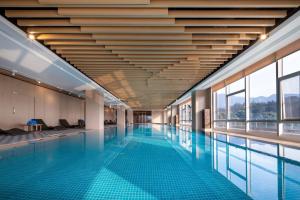 a swimming pool in a building with blue tiles at Four Points by Sheraton Chengdu, Pujiang Resort in Pujiang