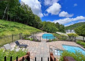 a backyard with a pool and a fence at Le Colvert by Rendez-Vous Mont-Tremblant in Mont-Tremblant