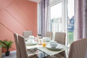 uma sala de jantar com uma mesa e cadeiras e uma janela em Arete Serviced Accommodation - 3 Bedrooms, 4 Beds, with Parking em Merstham