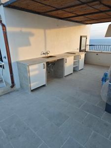 uma cozinha com um balcão e um lavatório e o oceano em Dimora San Felice Il Fico em Gallipoli