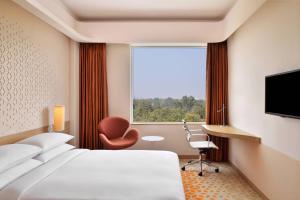 a hotel room with a bed and a window at Fairfield by Marriott Chennai Mahindra World City in Chengalpattu