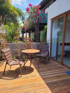 una terraza de madera con mesa y sillas. en Casa Makaira, en Fernando de Noronha