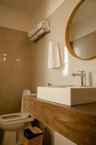 a bathroom with a sink and a toilet and a mirror at Casa Makaira in Fernando de Noronha
