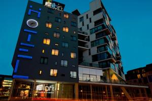 Un edificio alto con un reloj a un lado. en Aloft Brussels Schuman en Bruselas