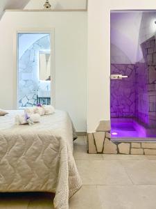 1 dormitorio con cama y pared púrpura en Messapica Home en Ceglie Messapica