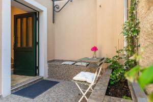 a table next to a door with a vase of flowers at Calafati Apartment with free private parking in Rijeka