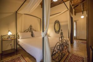 a bedroom with a four poster bed and a mirror at Ersis in Neochori
