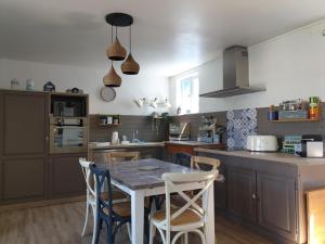 a kitchen with a table and chairs in it at Les Volets Bleus de Veules Les Roses in Veules-les-Roses