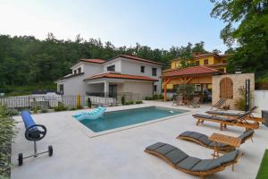 a backyard with a swimming pool and a house at Villa Suzana grijani bazen i biljar na otvorenom in Veprinac