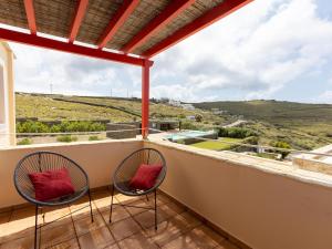 two chairs sitting on a balcony with a view at Bella Resorts Andros in Andros