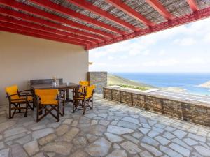 a patio with a table and chairs and the ocean at Bella Resorts Andros in Andros