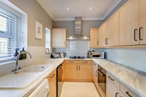 a kitchen with wooden cabinets and a sink at 3-bedroom home with free parking&flexible bed configuration in Harrogate