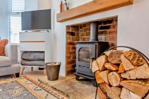 a living room with a brick fireplace with a wood stove at 3-bedroom home with free parking&flexible bed configuration in Harrogate