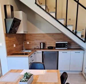 a kitchen under the stairs with a table and chairs at Złote Gąski in Gąski