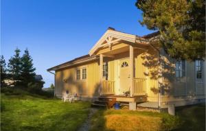 una casa amarilla con porche en un patio en Amazing Home In Drbak With Kitchen, en Drøbak