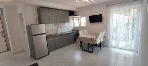 a kitchen with a small table and a refrigerator at Apartments INBOX in Kostrena
