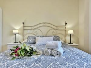 Una cama con una bandeja de toallas y flores. en Los Campizos - 6619, en Noja