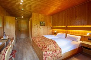 a bedroom with a large bed in a wooden room at Landhotel zur Grenze in Isny im Allgäu