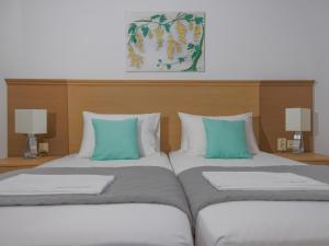 two beds sitting next to each other in a room at Bella Resorts Andros in Andros
