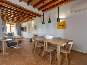 a dining room with a wooden table and chairs at Bella Resorts Andros in Andros