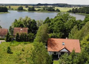 uma casa com vista para um rio e árvores em Mazurskie Siedlisko Langen em Mrągowo