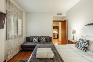 uma sala de estar com uma cama e um sofá em Charmoso Apartamento Sacavém em Sacavém