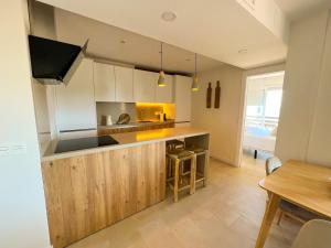 a kitchen with white cabinets and a counter top at Apartamentos Nogal in Aguadulce