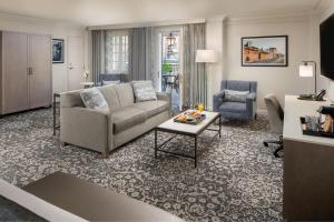 a living room with a couch and a table at Four Points by Sheraton French Quarter in New Orleans