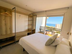 a bedroom with a bed with a view of the ocean at Apartamentos Nogal in Aguadulce
