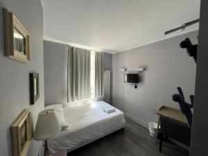 Habitación pequeña con cama y ventana en Petticoat Accommodations en Londres