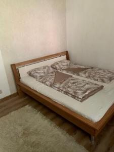 uma cama com uma estrutura de madeira e um colchão branco em Apartament 3 camere Joy em Ocna-Mureşului