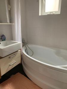 uma casa de banho com uma banheira, um lavatório, uma banheira branca e um lavatório. em Apartament 3 camere Joy em Ocna-Mureşului