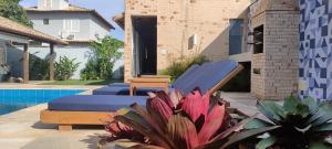 um quintal com uma cama e uma piscina em Casa Azul Hibisco - Geriba Buzios em Búzios