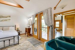 a bedroom with a bed and a tub at Scenic Eureka Springs Cabin Rental with Balcony! in Garfield
