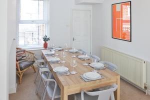 a dining room with a wooden table and chairs at 3-bedroom home with free parking&flexible bed configuration in Harrogate