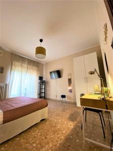 1 dormitorio con cama, escritorio y lavamanos en Casa Viola a 900 mt dalla Staz. Centrale en Pescara
