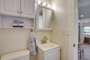 een badkamer met een wastafel, een toilet en een spiegel bij Pet-Friendly Benton Harbor Home Near Hagar Beach! in Benton Harbor