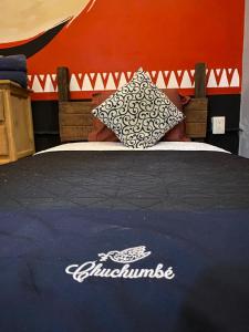ein Bett mit einer blauen Decke und einem Kissen darauf in der Unterkunft Chuchumbé Hotel & Hostal in Veracruz