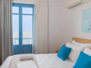 a bedroom with a large bed with a window at Bella Resorts Andros in Andros